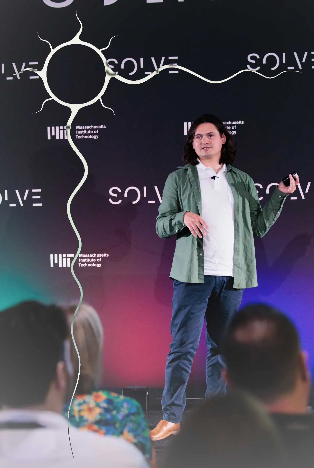 Nodin Cutfeet on stage, presenting at an MIT Solve event.